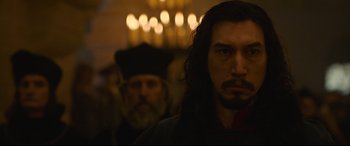 Movie still from “The Last Duel” (2021), directed by Ridley Scott – A man with long black hair standing next to another man with long black hair; Close Up shot, Over the shoulder angle