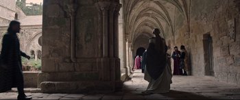 Movie still from “The Last Duel” (2021), directed by Ridley Scott – A group of people walking through a hallway; Wide shot, Low angle