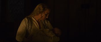 Movie still from “The Last Duel” (2021), directed by Ridley Scott – A woman holding a baby in her arms in the dark; Close Up shot, Over the shoulder angle
