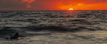 Movie still from “Baywatch” (2017), directed by Seth Gordon – The sun is setting over the ocean as seen from a boat; Extreme Wide shot, High angle