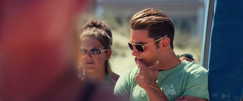 Movie still from “Baywatch” (2017), directed by Seth Gordon – A man and a woman wearing sunglasses sitting next to each other; Close Up shot, Over the shoulder angle