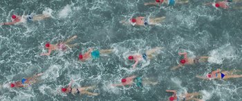 Movie still from “Baywatch” (2017), directed by Seth Gordon – A group of people swimming in the water; Extreme Wide shot, Overhead angle