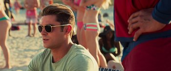 Movie still from “Baywatch” (2017), directed by Seth Gordon – A man sitting in front of a group of women; Close Up shot, Over the shoulder angle