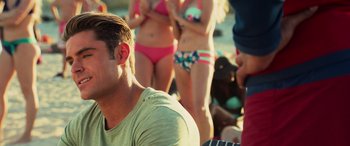 Movie still from “Baywatch” (2017), directed by Seth Gordon – A group of people in bathing suits standing next to each other on the beach; Close Up shot, Over the shoulder angle