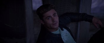 Movie still from “Baywatch” (2017), directed by Seth Gordon – A young man in a leather jacket posing for a picture; Close Up shot, High angle