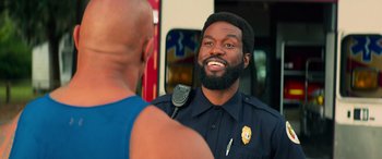 Movie still from “Baywatch” (2017), directed by Seth Gordon – A police officer talking to a man in a blue shirt; Close Up shot, Over the shoulder angle