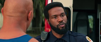 Movie still from “Baywatch” (2017), directed by Seth Gordon – A man with a beard is talking to someone; Close Up shot, Over the shoulder angle