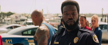 Movie still from “Baywatch” (2017), directed by Seth Gordon – A man in a police uniform and a man in a police uniform; Close Up shot, Over the shoulder angle