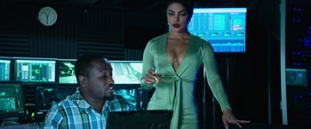 Movie still from “Baywatch” (2017), directed by Seth Gordon – A woman in a green dress holding a glass of wine; Medium shot, Over the shoulder angle
