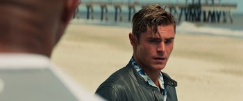 Movie still from “Baywatch” (2017), directed by Seth Gordon – A man in a leather jacket looking to his left; Close Up shot, Over the shoulder angle