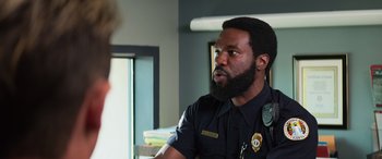 Movie still from “Baywatch” (2017), directed by Seth Gordon – A man with a beard is wearing a police uniform; Close Up shot, Over the shoulder angle
