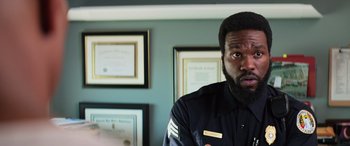 Movie still from “Baywatch” (2017), directed by Seth Gordon – A man with a beard wearing a police uniform; Close Up shot, Over the shoulder angle