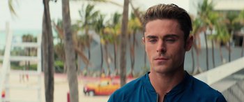Movie still from “Baywatch” (2017), directed by Seth Gordon – A man in a blue shirt is looking at the camera; Close Up shot, Over the shoulder angle