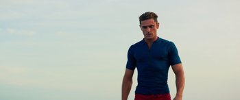 Movie still from “Baywatch” (2017), directed by Seth Gordon – A man in a blue shirt and red pants; Medium shot, Low angle
