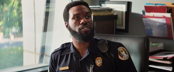 Movie still from “Baywatch” (2017), directed by Seth Gordon – A man in a police uniform with a beard; Close Up shot, Over the shoulder angle