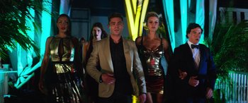 Movie still from “Baywatch” (2017), directed by Seth Gordon – A group of people walking in a room at a party; Medium shot, Low angle