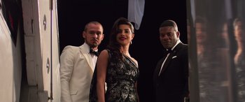 Movie still from “Baywatch” (2017), directed by Seth Gordon – A woman standing between two men in tuxedos; Medium shot, Low angle