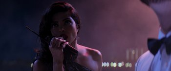 Movie still from “Baywatch” (2017), directed by Seth Gordon – A woman in a black dress holding her hand to her mouth; Close Up shot, Over the shoulder angle