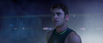 Movie still from “Baywatch” (2017), directed by Seth Gordon – A man in a black tank top is looking to his left; Close Up shot, Over the shoulder angle