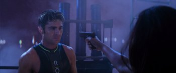 Movie still from “Baywatch” (2017), directed by Seth Gordon – A man holding a gun pointed at another man; Close Up shot, Over the shoulder angle
