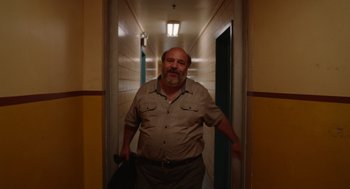 Movie still from “Beau Is Afraid” (2023), directed by Ari Aster – A man standing in a hallway holding a suitcase; Medium shot, Low angle