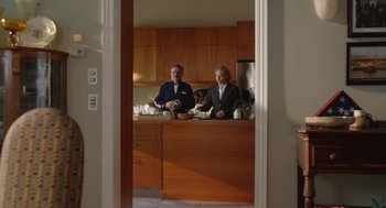 Movie still from “Beau Is Afraid” (2023), directed by Ari Aster – Two people standing at a counter in a kitchen; Wide shot, Over the shoulder angle