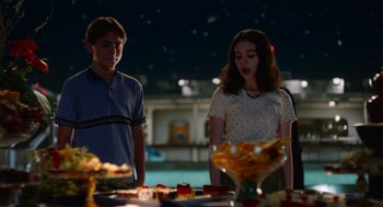 Movie still from “Beau Is Afraid” (2023), directed by Ari Aster – A man and a woman standing in front of a bowl of food; Medium shot, Over the shoulder angle