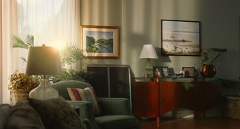 Movie still from “Beau Is Afraid” (2023), directed by Ari Aster – A living room filled with furniture next to a window; Wide shot, Low angle