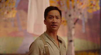 Movie still from “Beau Is Afraid” (2023), directed by Ari Aster – A man in a tan shirt and suspenders looks into the camera; Close Up shot, Low angle