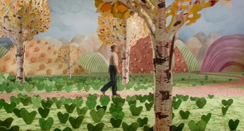 Movie still from “Beau Is Afraid” (2023), directed by Ari Aster – A painting of a man walking in a field of paper hearts; Extreme Wide shot, High angle