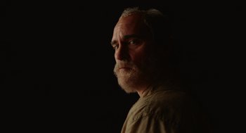 Movie still from “Beau Is Afraid” (2023), directed by Ari Aster – An old man with a beard is looking into the distance; Close Up shot, Low angle