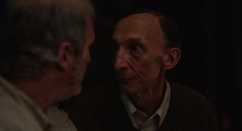 Movie still from “Beau Is Afraid” (2023), directed by Ari Aster – Two older men are looking at one another; Close Up shot, Over the shoulder angle