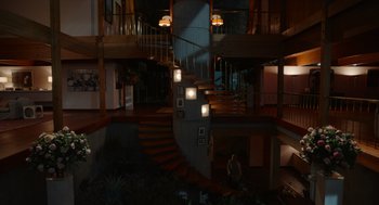 Movie still from “Beau Is Afraid” (2023), directed by Ari Aster – A man sitting on the steps of a spiral staircase; Extreme Wide shot, High angle