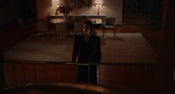 Movie still from “Beau Is Afraid” (2023), directed by Ari Aster – A woman standing in front of a railing in a room; Wide shot, Low angle