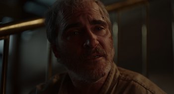 Movie still from “Beau Is Afraid” (2023), directed by Ari Aster – An older man with a beard and mustache looking at the camera; Close Up shot, Over the shoulder angle