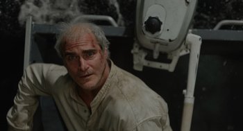 Movie still from “Beau Is Afraid” (2023), directed by Ari Aster – A man in a white shirt is looking at the camera; Close Up shot, High angle