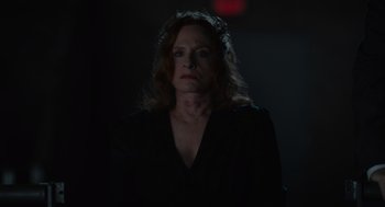 Movie still from “Beau Is Afraid” (2023), directed by Ari Aster – A woman in a black shirt is in the dark; Close Up shot, Over the shoulder angle