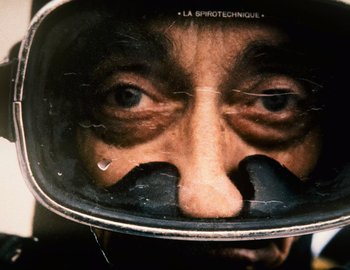 Movie still from “Becoming Cousteau” (2021), directed by Liz Garbus – A man's face is reflected in a mirror; Extreme Close Up shot, Overhead angle