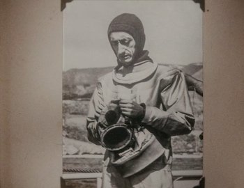 Movie still from “Becoming Cousteau” (2021), directed by Liz Garbus – An old photo of a man holding a baseball glove; Medium shot, High angle
