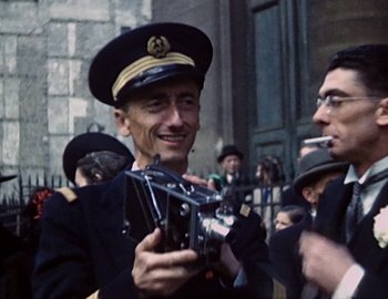 Movie still from “Becoming Cousteau” (2021), directed by Liz Garbus – A man in a uniform holding a camera; Close Up shot, Low angle