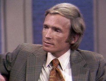 Movie still from “Becoming Cousteau” (2021), directed by Liz Garbus – A person wearing a suit and tie; Close Up shot, High angle