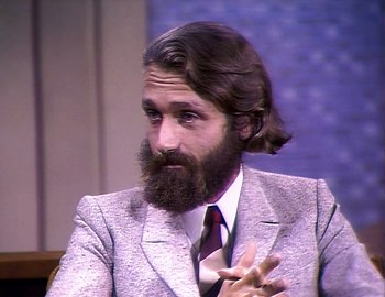 Movie still from “Becoming Cousteau” (2021), directed by Liz Garbus – A man in a suit and a tie is sitting down; Close Up shot, High angle