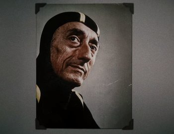Movie still from “Becoming Cousteau” (2021), directed by Liz Garbus – An older man wearing a black and yellow outfit; Extreme Close Up shot, High angle