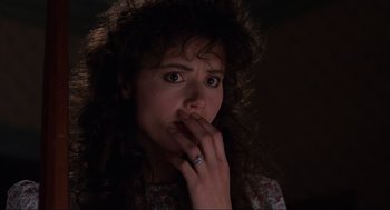 Movie still from “Beetlejuice” (1988), directed by Tim Burton – A person holding their hand to her mouth; Close Up shot, Over the shoulder angle