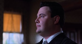 Movie still from “Beetlejuice” (1988), directed by Tim Burton – A person wearing a suit and tie; Close Up shot, Low angle