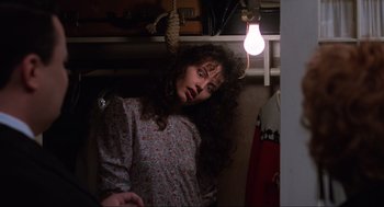 Movie still from “Beetlejuice” (1988), directed by Tim Burton – A woman with curly brown hair is posing for the camera; Medium shot, Low angle