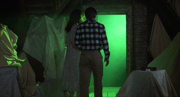 Movie still from “Beetlejuice” (1988), directed by Tim Burton – A man and a woman standing in front of an open door; Wide shot, Over the shoulder angle