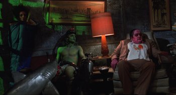 Movie still from “Beetlejuice” (1988), directed by Tim Burton – A man sitting next to another man in a room; Wide shot, Low angle