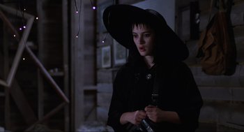 Movie still from “Beetlejuice” (1988), directed by Tim Burton – A young woman in a witch's outfit holding a cell phone; Medium shot, Low angle
