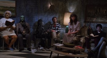 Movie still from “Beetlejuice” (1988), directed by Tim Burton – A group of people sitting in a living room next to each other; Wide shot, Low angle
